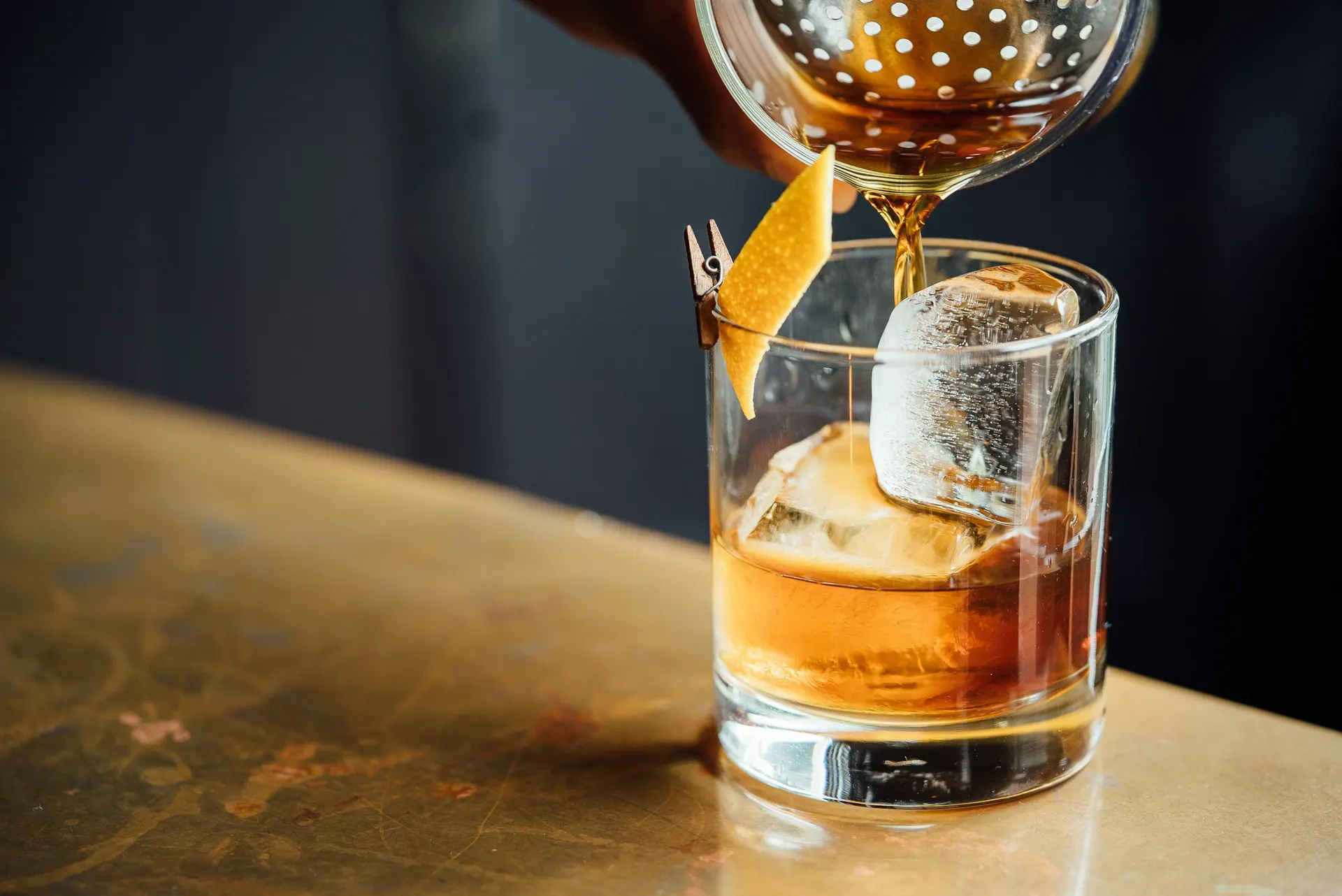 Bartendern silar upp en cocktail i baren
